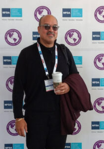 Adrian Gardner stands in front of Funeral Conference branded wall.